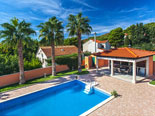 Outside palm tree rental villa with pool in Sumartin on Brač Island in Dalmatia in Croatia