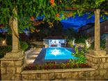 View on the pool area from the courtyard of this Dubrovnik holiday villa by night