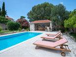 Sunchairs on the pool side with the pool cottage in the background in front of this Dubrovnik holiday villa